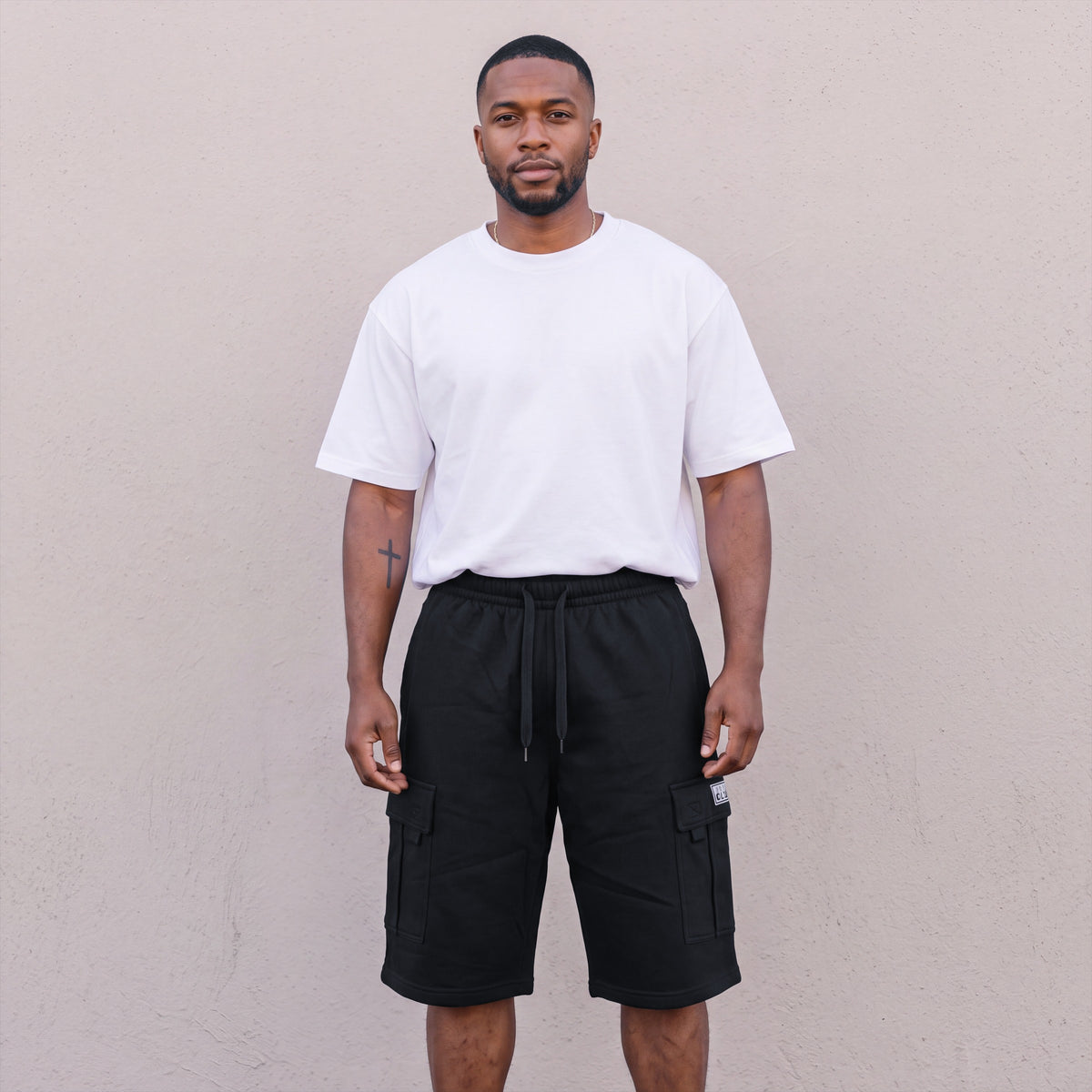 Model wearing Pro Club Men's Fleece Cargo Shorts in Black