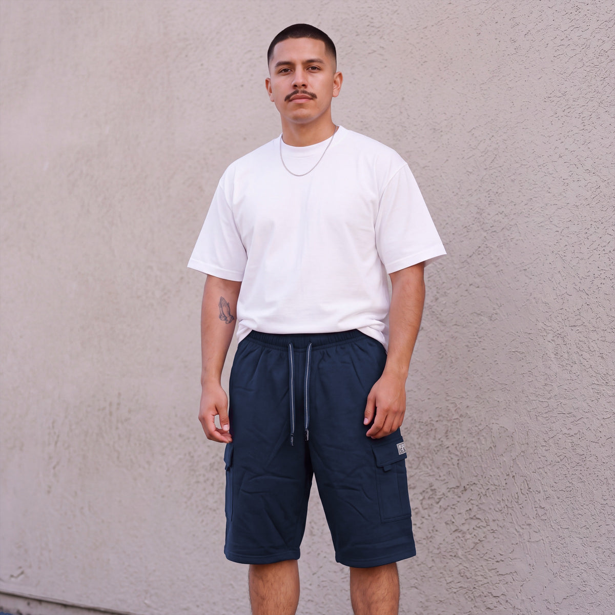 Model wearing Pro Club Men's Fleece Cargo Shorts in Navy