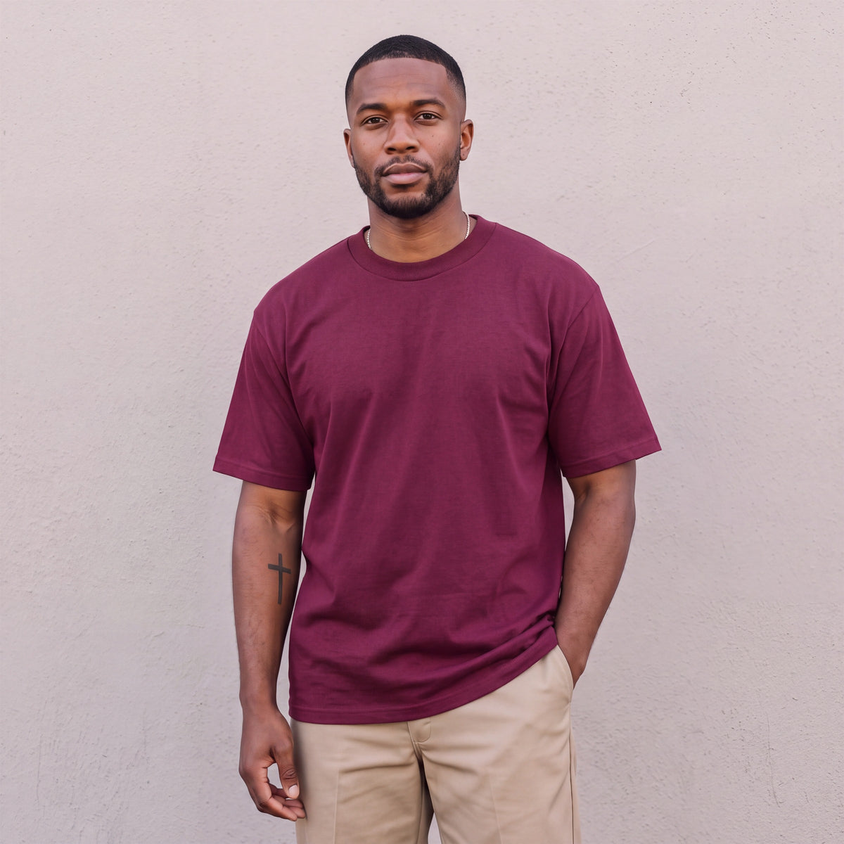 Model wearing Pro Club Men's Heavyweight Cotton Short Sleeve Crew Neck T-Shirt in Burgundy