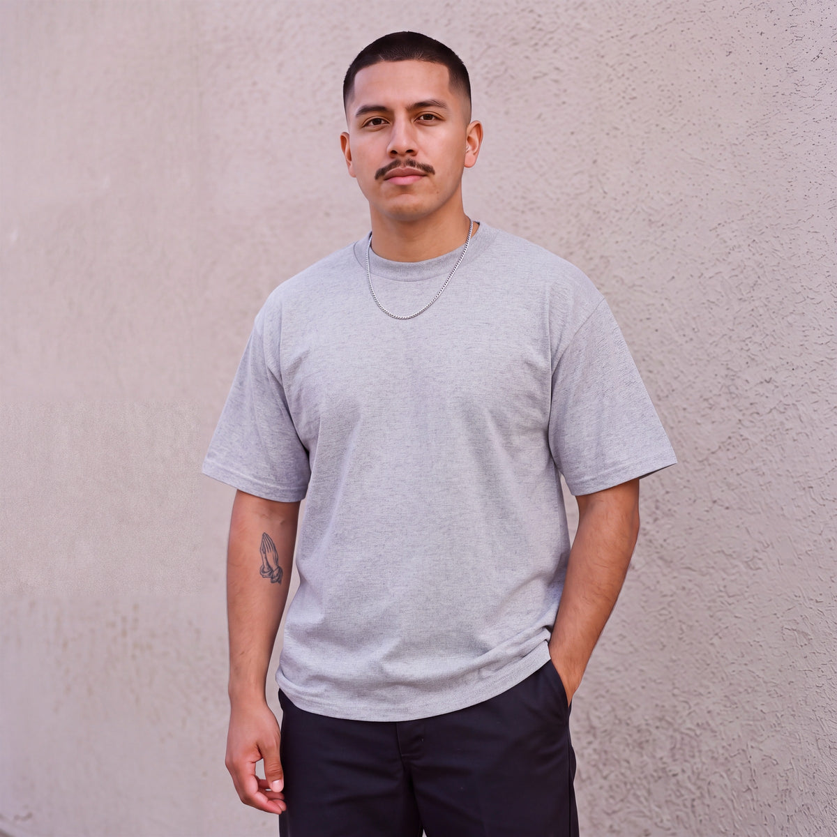 Model wearing Pro Club Men's Heavyweight Cotton Short Sleeve Crew Neck T-Shirt in Heather Grey