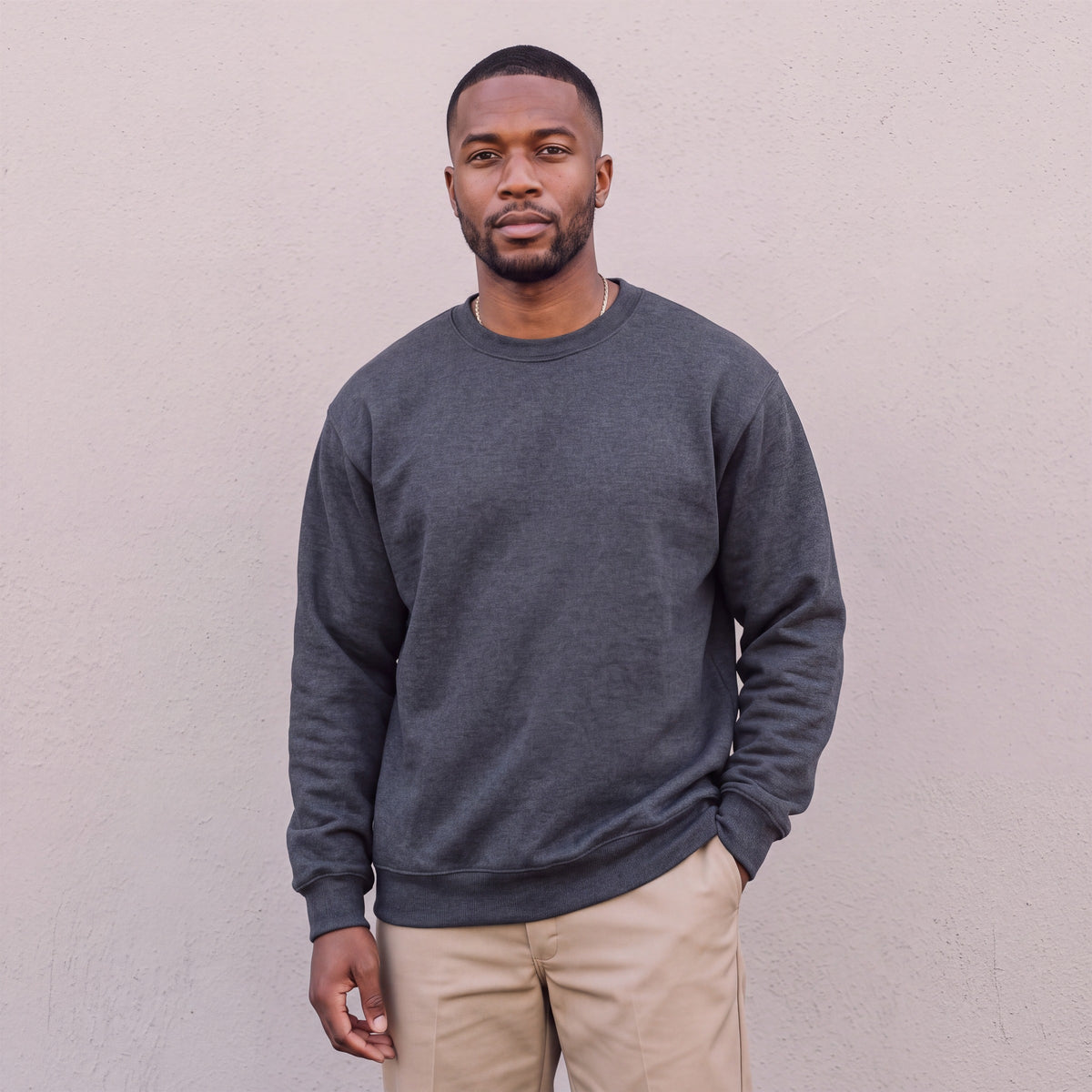 Model wearing Pro Club Men's Heavyweight Crew Neck Fleece Pullover Sweater (13oz) in Charcoal