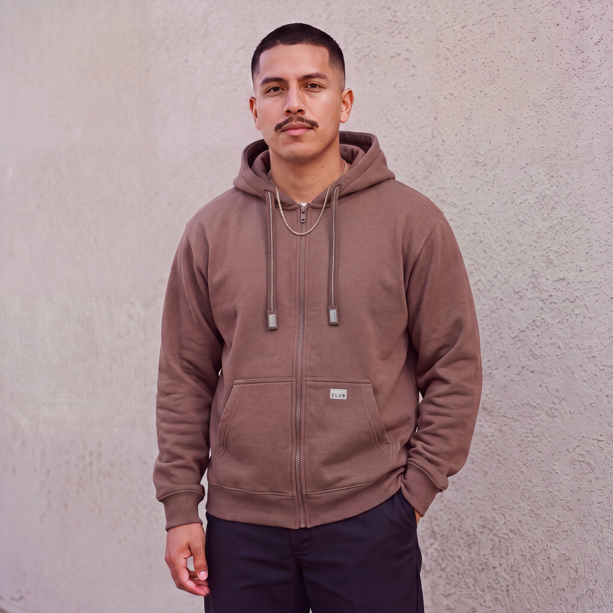 Model wearing Pro Club Men's Heavyweight Full Zip Fleece Hoodie in Brown