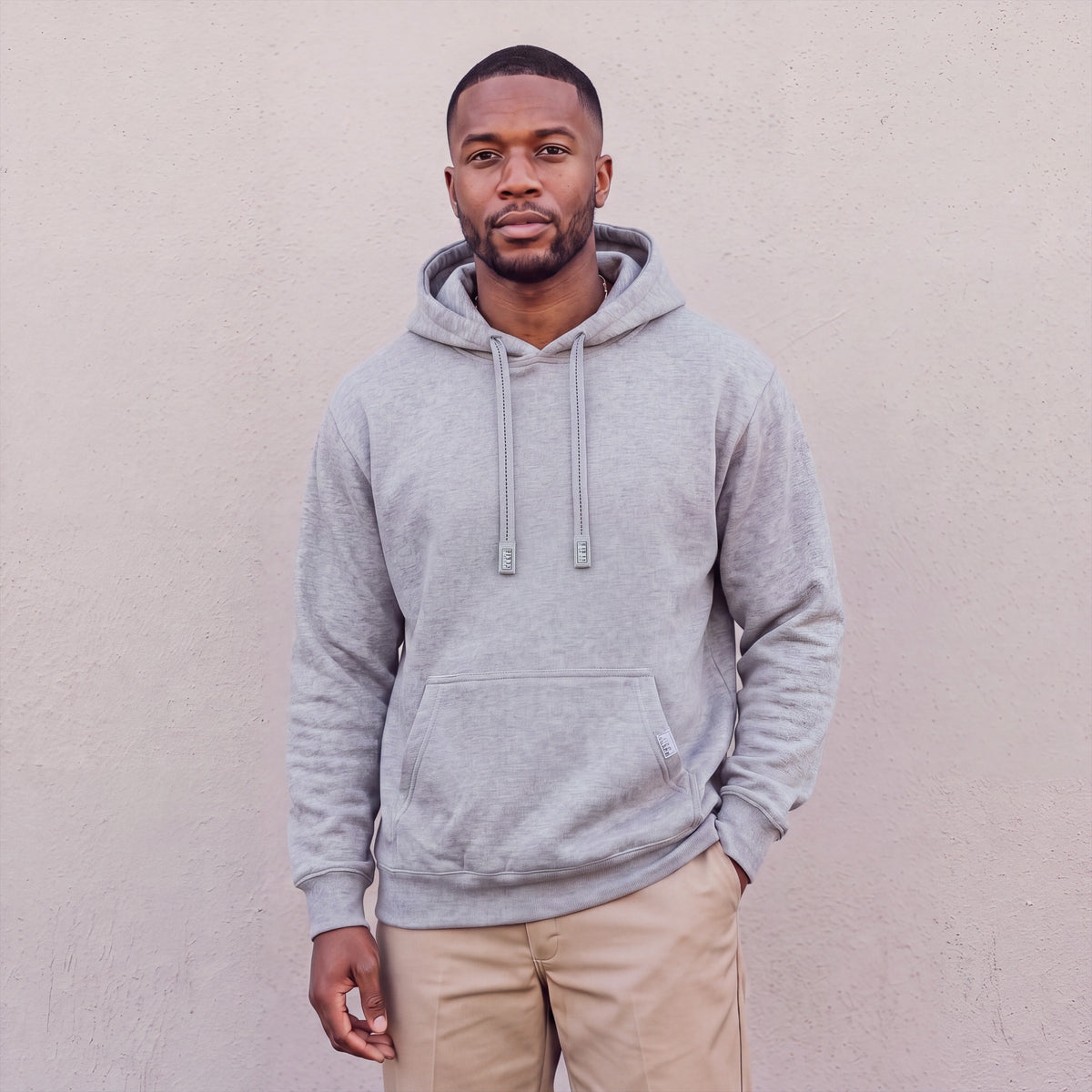 Model wearing Pro Club Men's Heavyweight Pullover Hoodie (13oz) in Heather Grey
