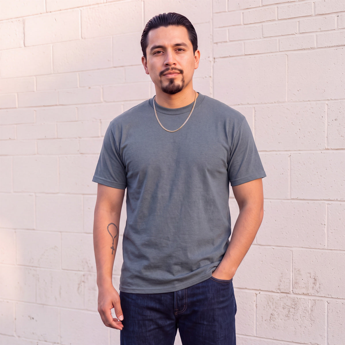 Model wearing Shaka Wear 6.0 oz Active Short Sleeve T-Shirt in Dark Grey
