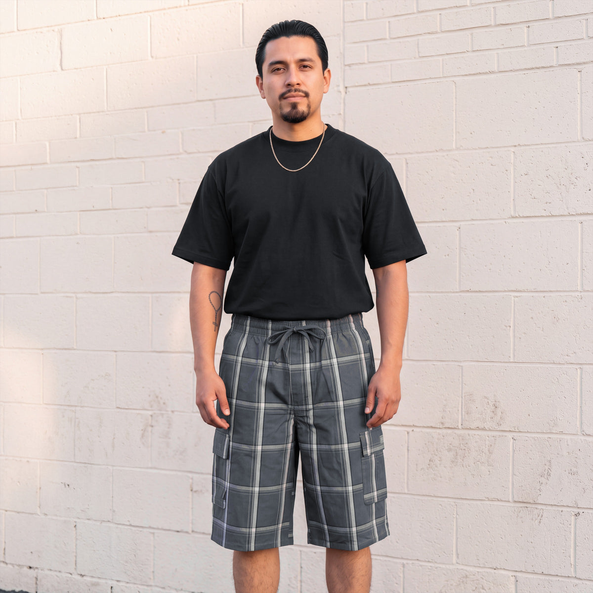 Model wearing Shaka Wear Plaid Shorts in Dark Grey