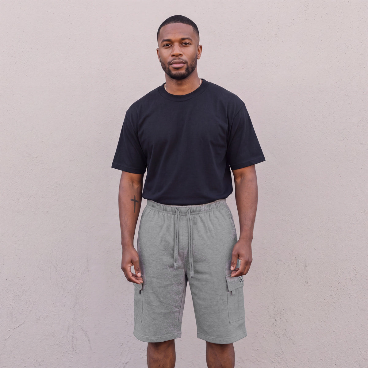 Model wearing Pro Club Men's Fleece Cargo Shorts in Heather Grey