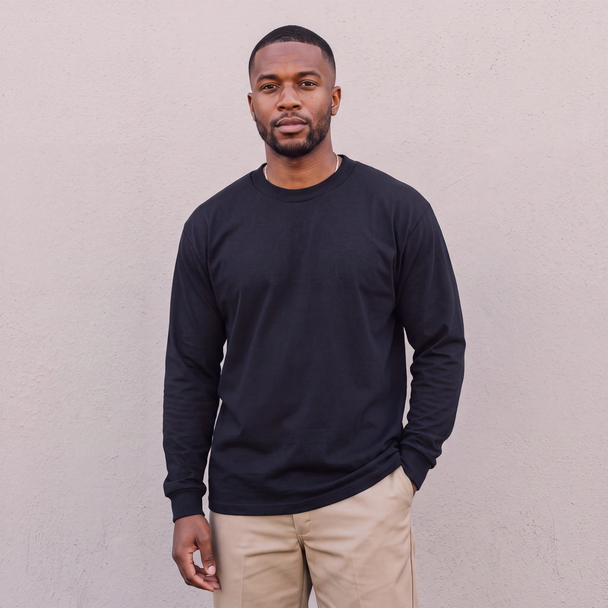 Model wearing Pro Club Men's Heavyweight Cotton Long Sleeve Crew Neck T-Shirt in Black