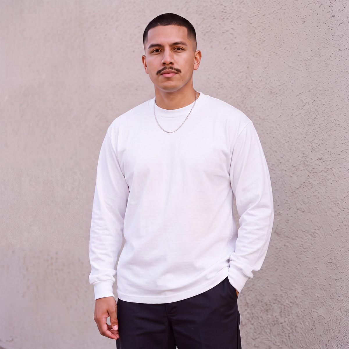Model wearing Pro Club Men's Heavyweight Cotton Long Sleeve Crew Neck T-Shirt in White