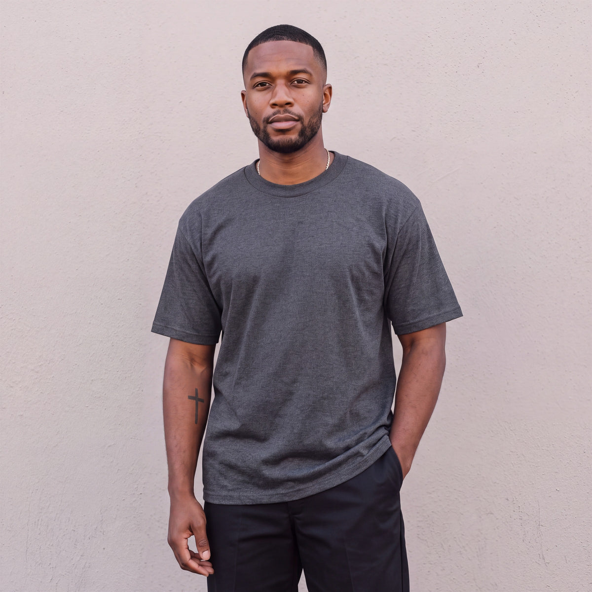 Model wearing Pro Club Men's Heavyweight Cotton Short Sleeve Crew Neck T-Shirt in Charcoal