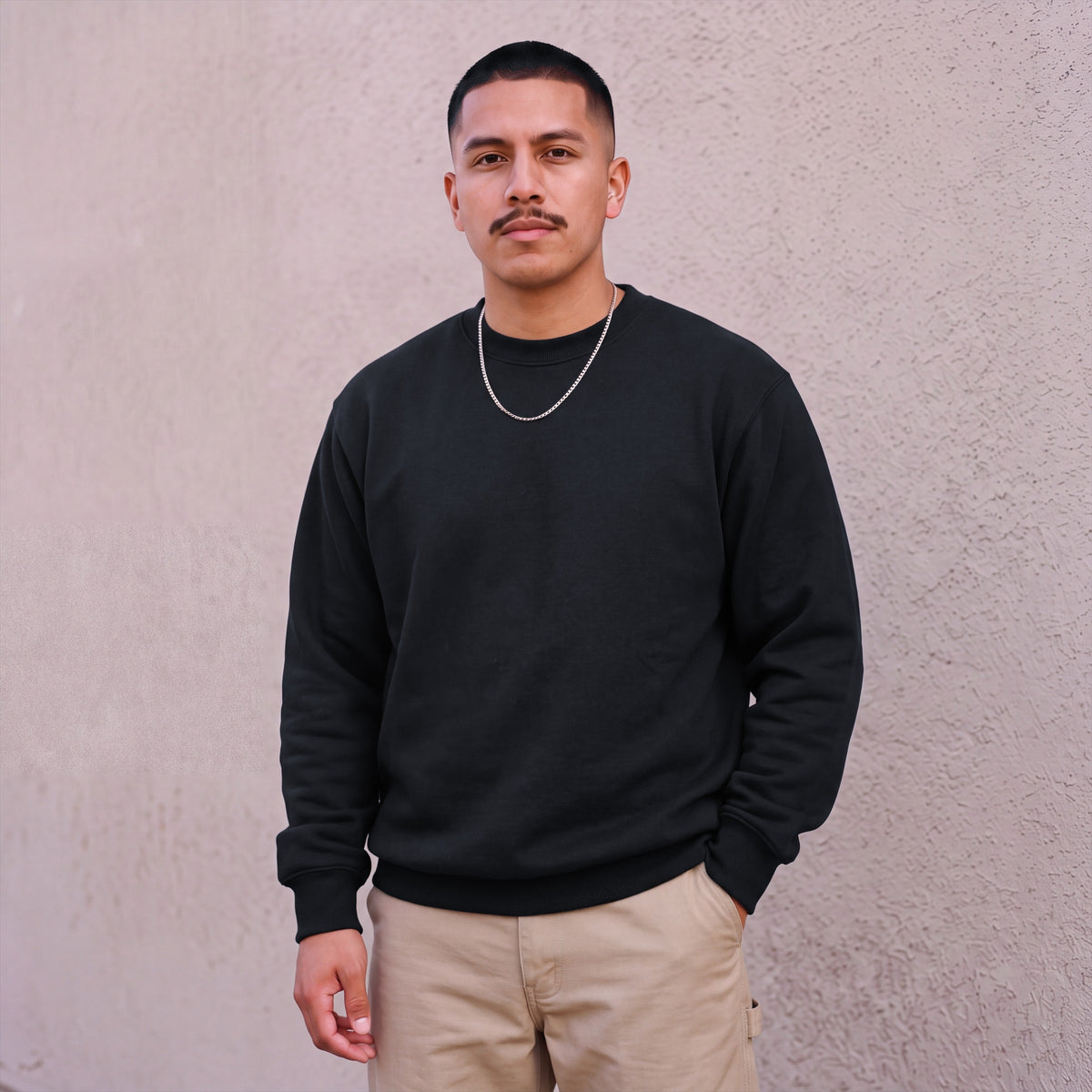 Model wearing Pro Club Men's Heavyweight Crew Neck Fleece Pullover Sweater (13oz) in Black
