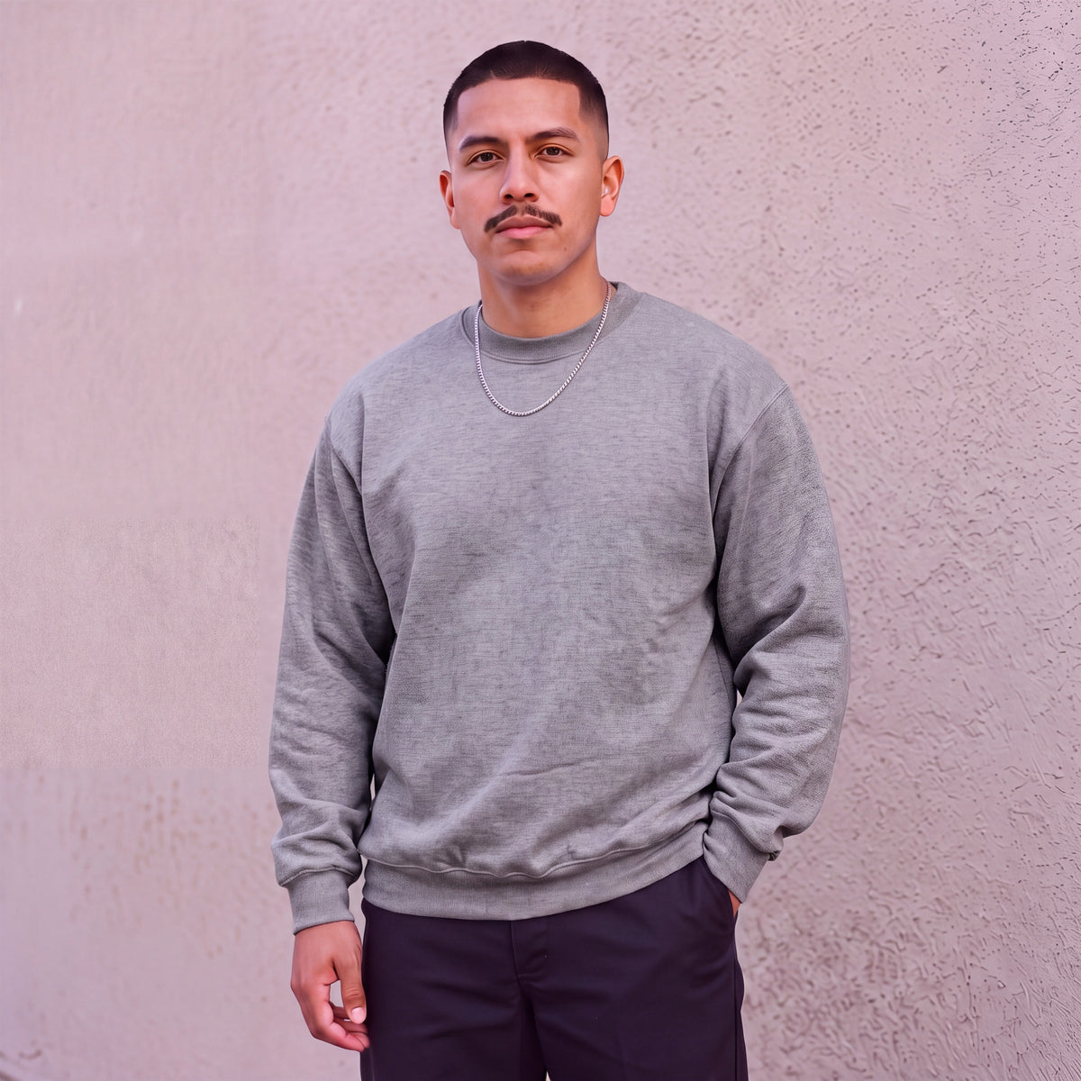 Model wearing Pro Club Men's Heavyweight Crew Neck Fleece Pullover Sweater (13oz) in Heather Grey