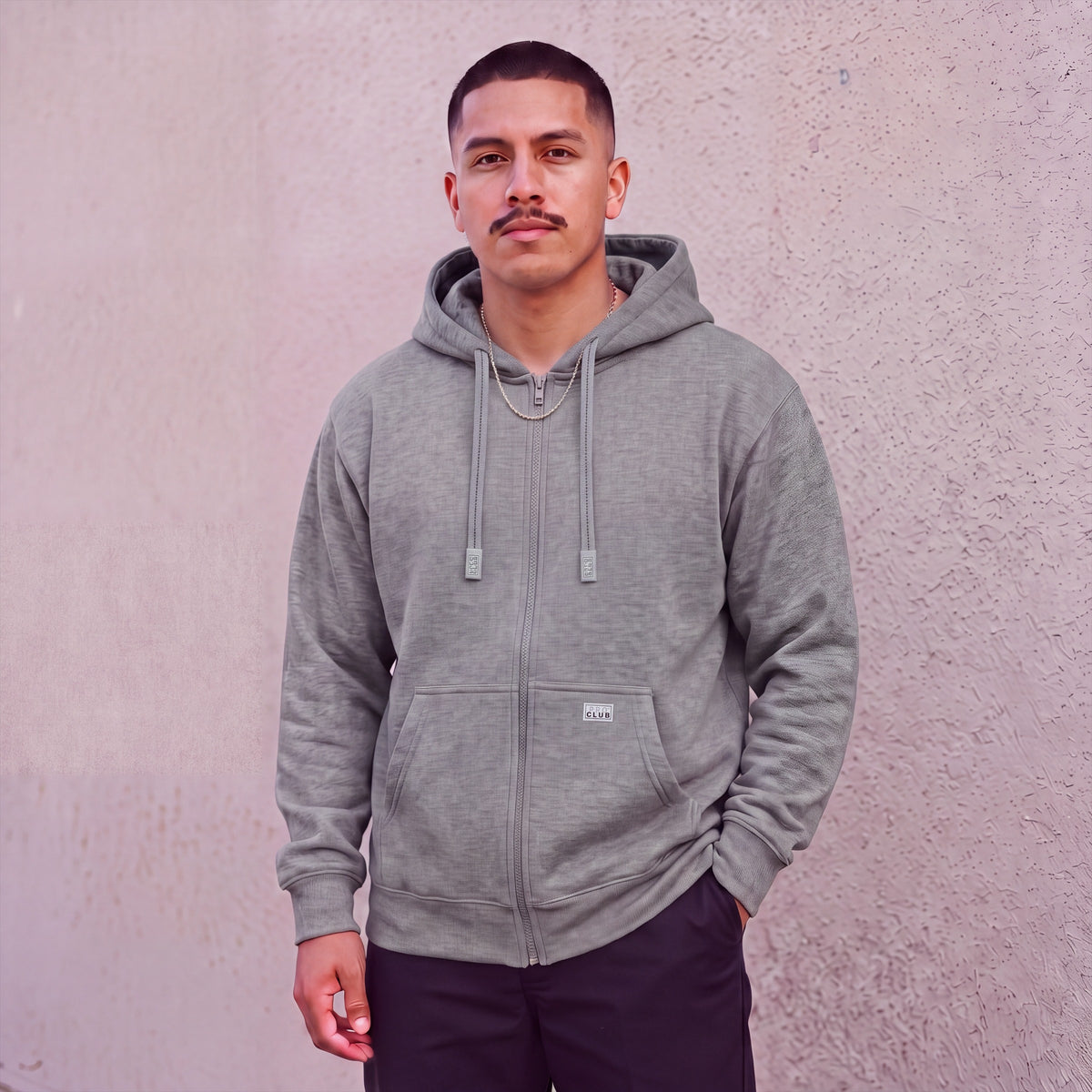 Model wearing Pro Club Men's Heavyweight Full Zip Fleece Hoodie in Heather Grey