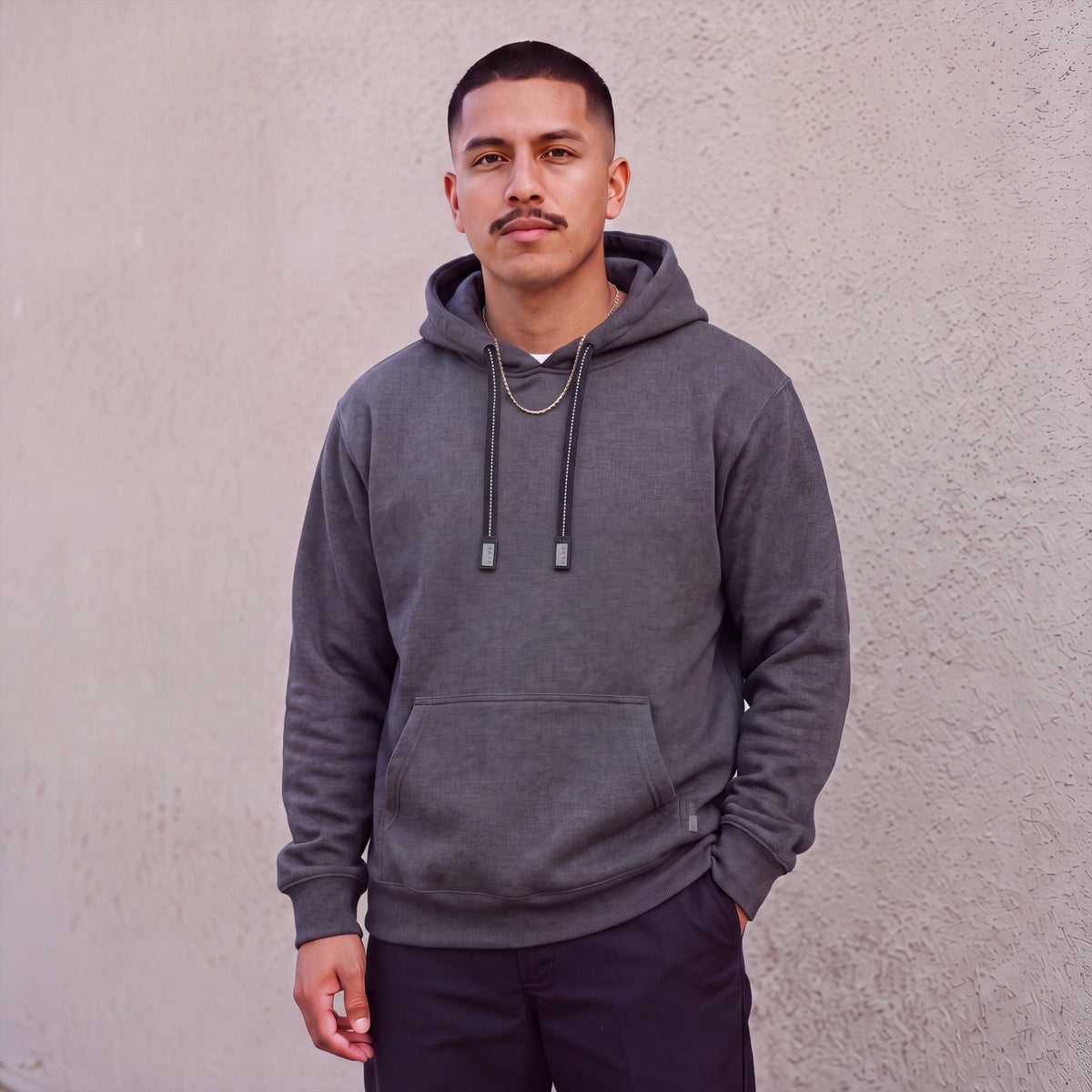 Model wearing Pro Club Men's Heavyweight Pullover Hoodie (13oz) in Charcoal