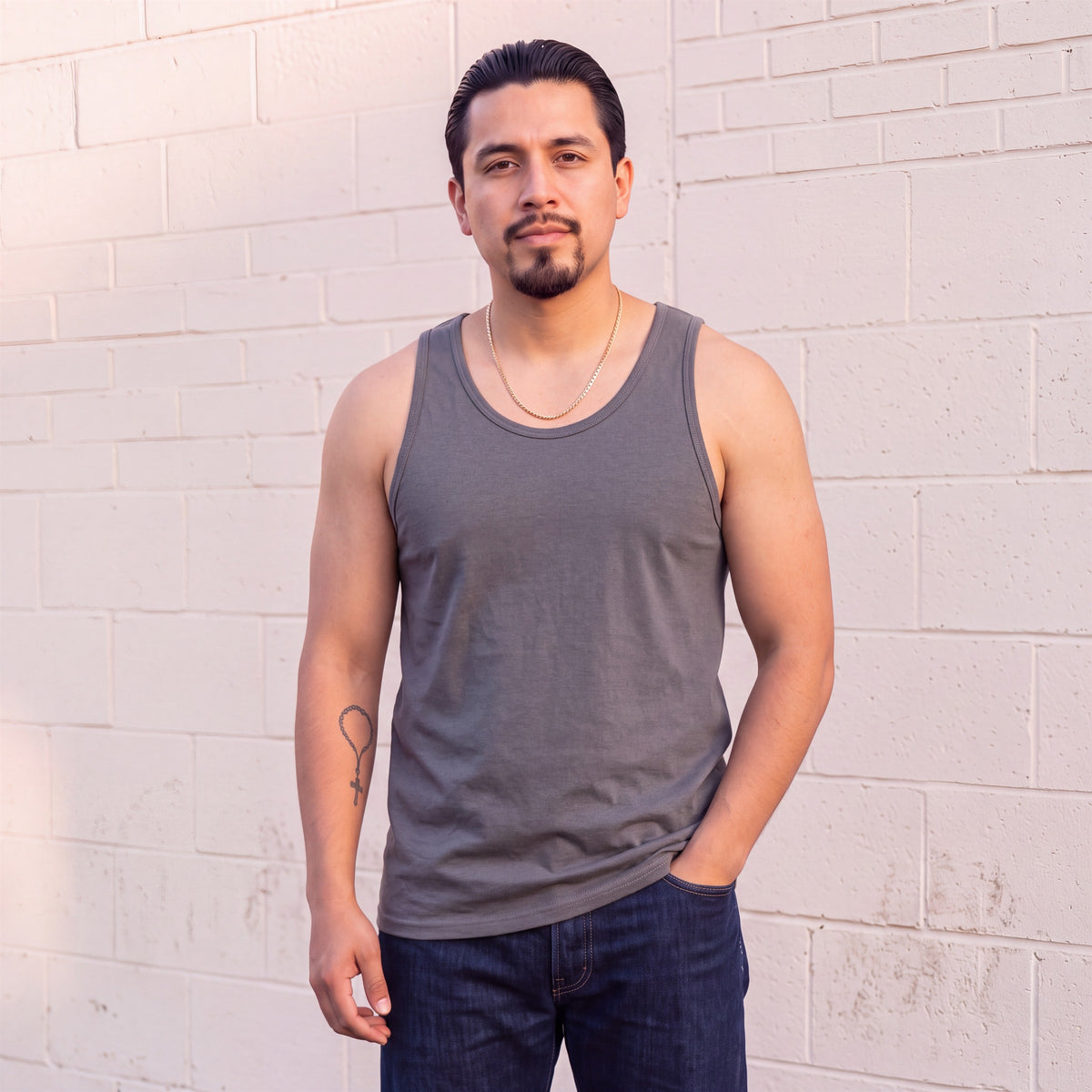 Model wearing Shaka Wear 6.0 Oz Tank Top in Dark Grey