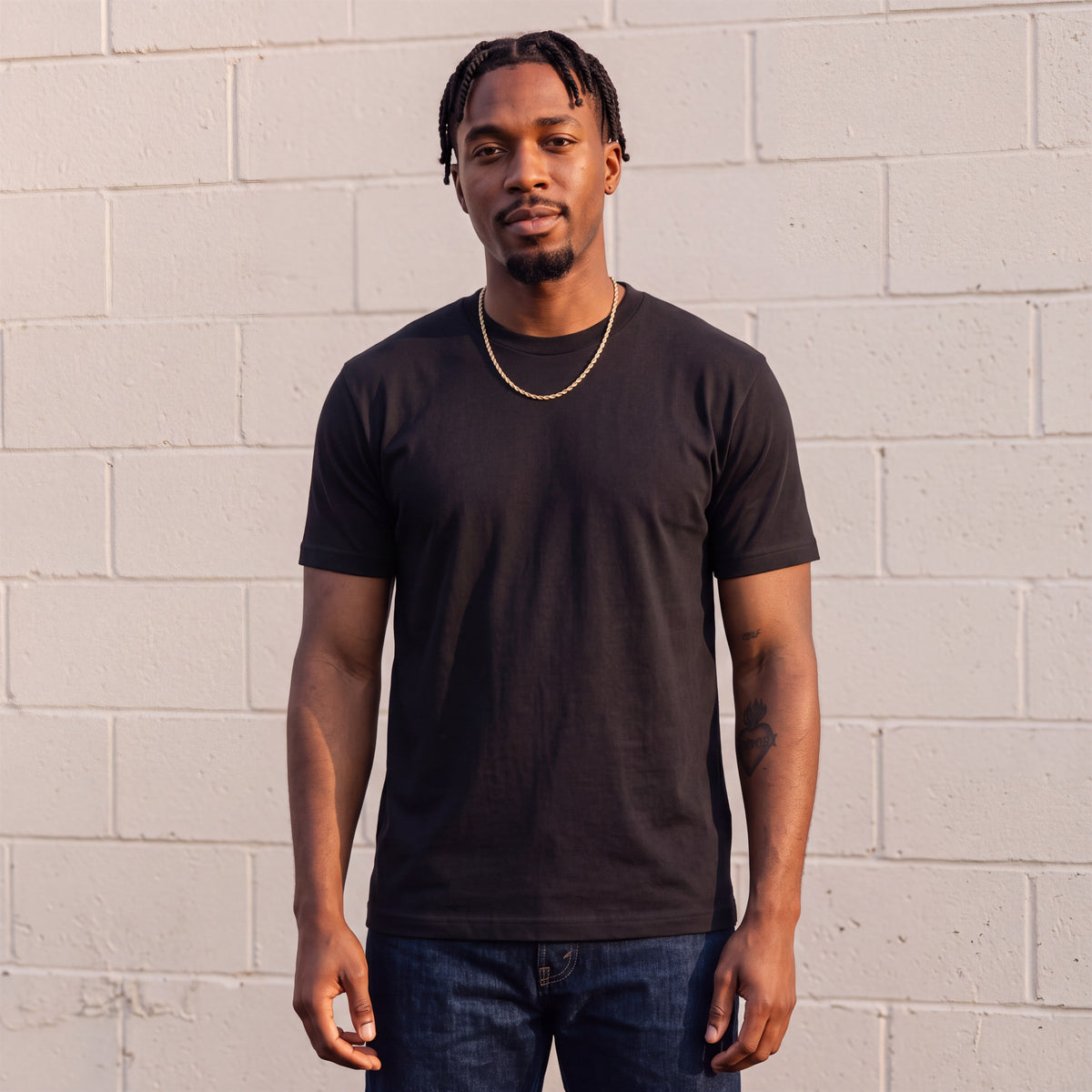 Model wearing Shaka Wear 6.0 oz Active Short Sleeve T-Shirt in Black