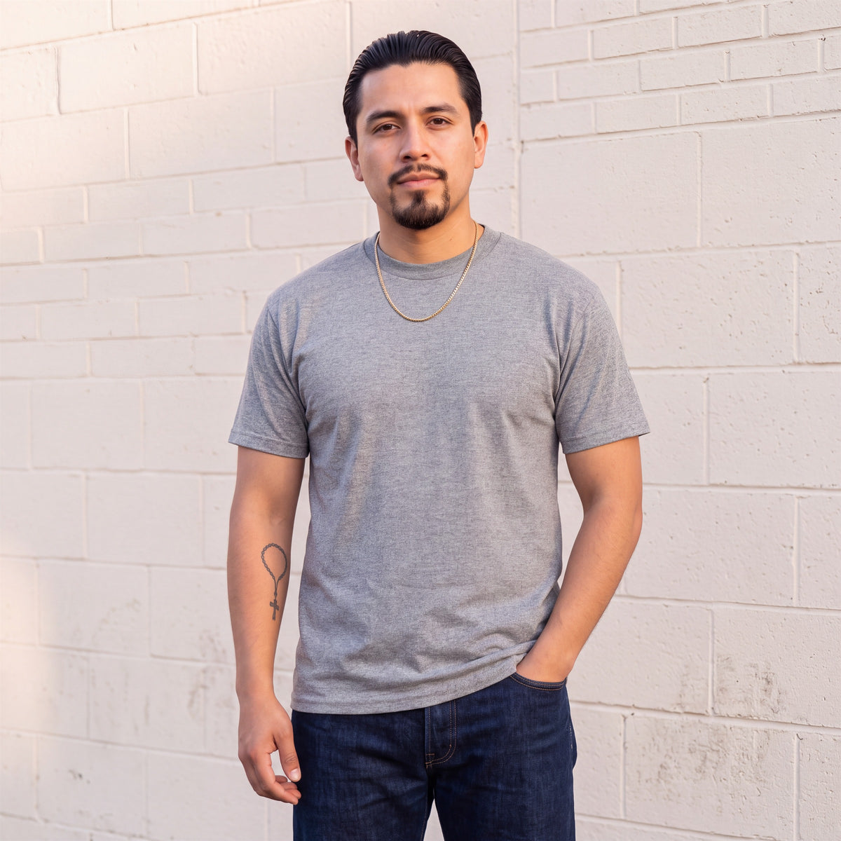 Model wearing Shaka Wear 6.0 oz Active Short Sleeve T-Shirt in Heather Grey