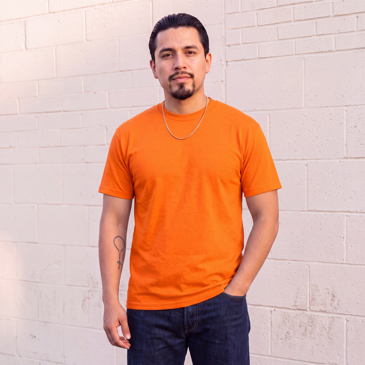 Model wearing Shaka Wear 6.0 oz Active Short Sleeve T-Shirt in Orange