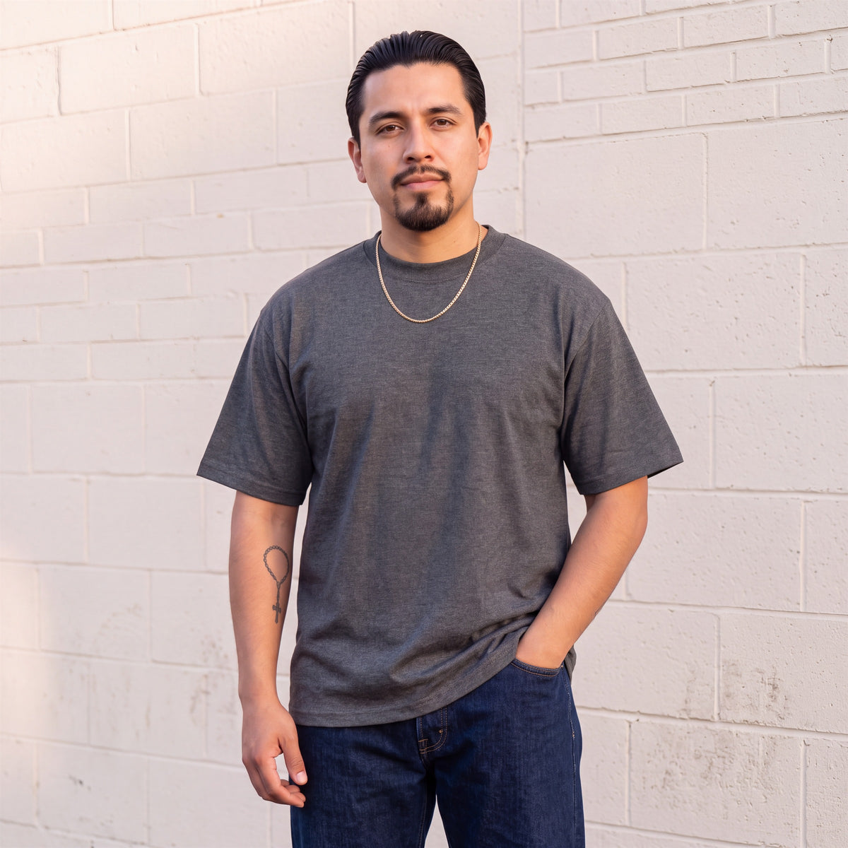 Model wearing Shaka Wear 7.5 oz Max Heavyweight Short Sleeve T-Shirt in Charcoal