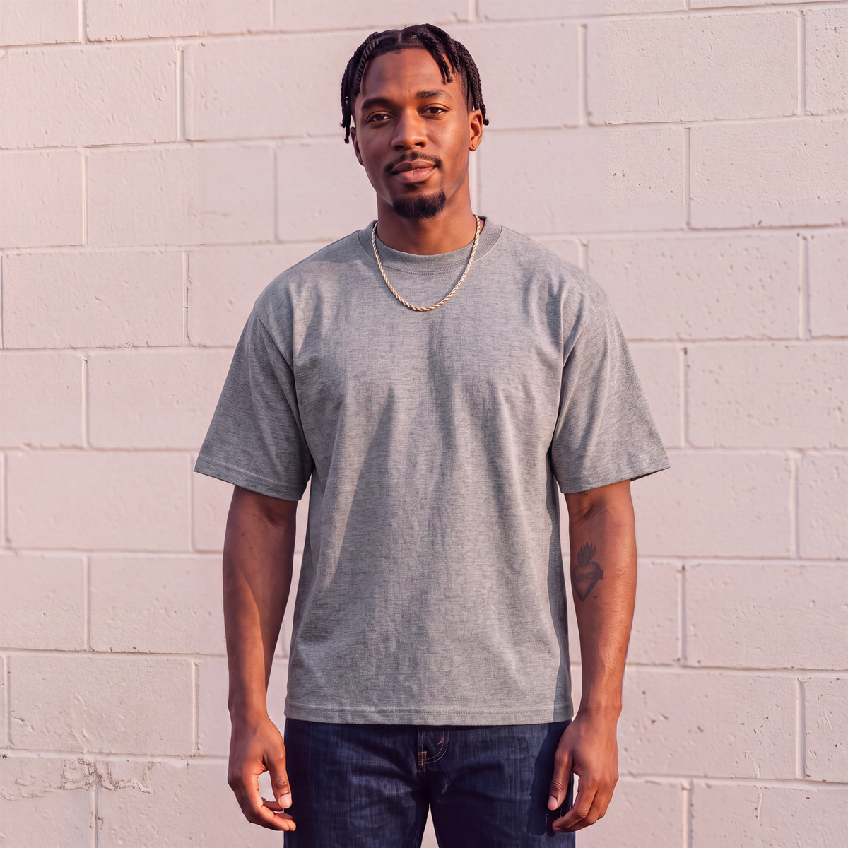 Model wearing Shaka Wear 7.5 oz Max Heavyweight Short Sleeve T-Shirt in Heather Grey