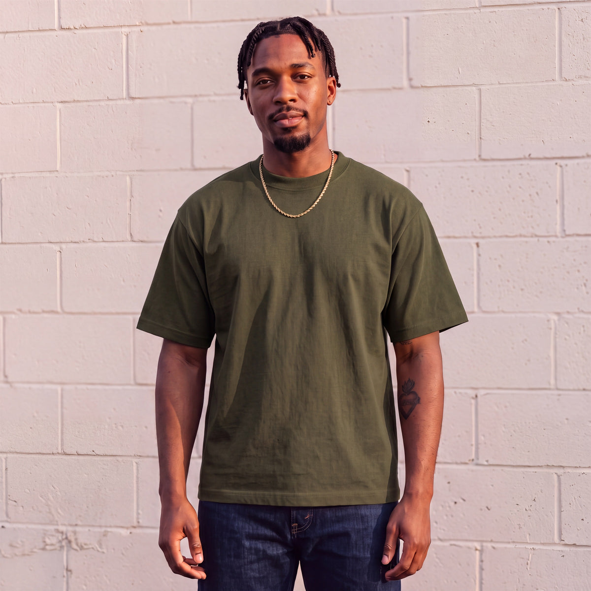 Model wearing Shaka Wear 7.5 oz Max Heavyweight Short Sleeve T-Shirt in Olive