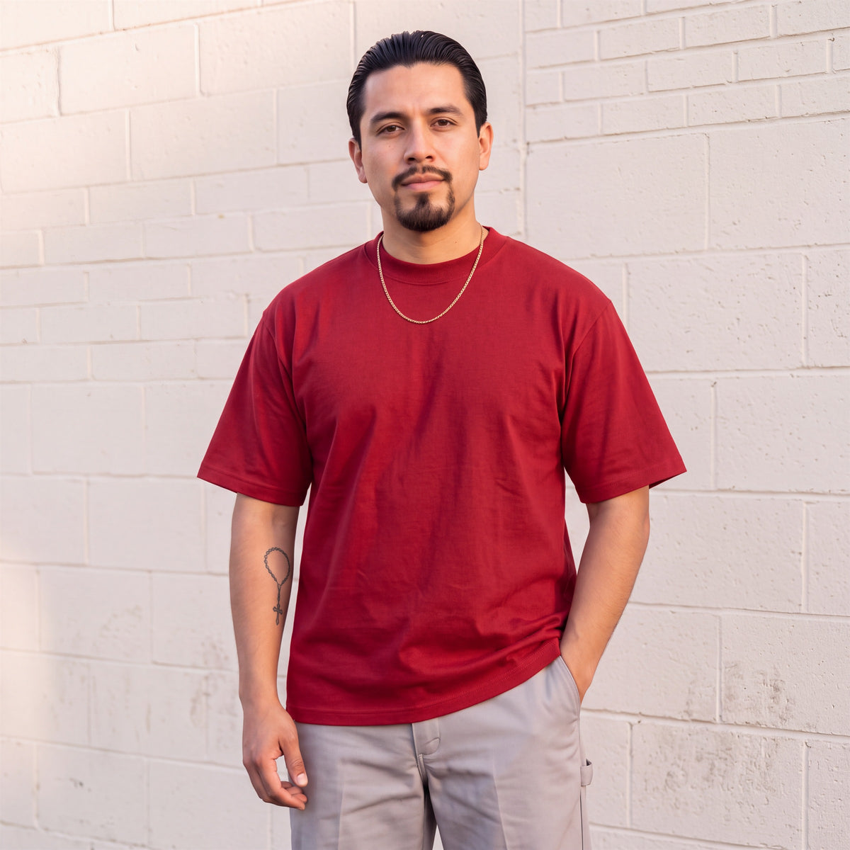 Model wearing Shaka Wear 7.5 oz Max Heavyweight Short Sleeve T-Shirt in Red